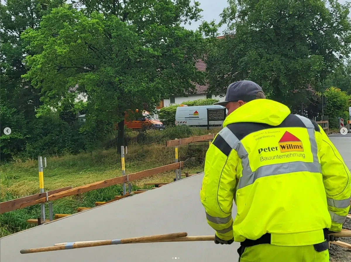 Mitarbeiter der Peter Willms Bauunternehmung auf der neuen Fahrbahnplatte