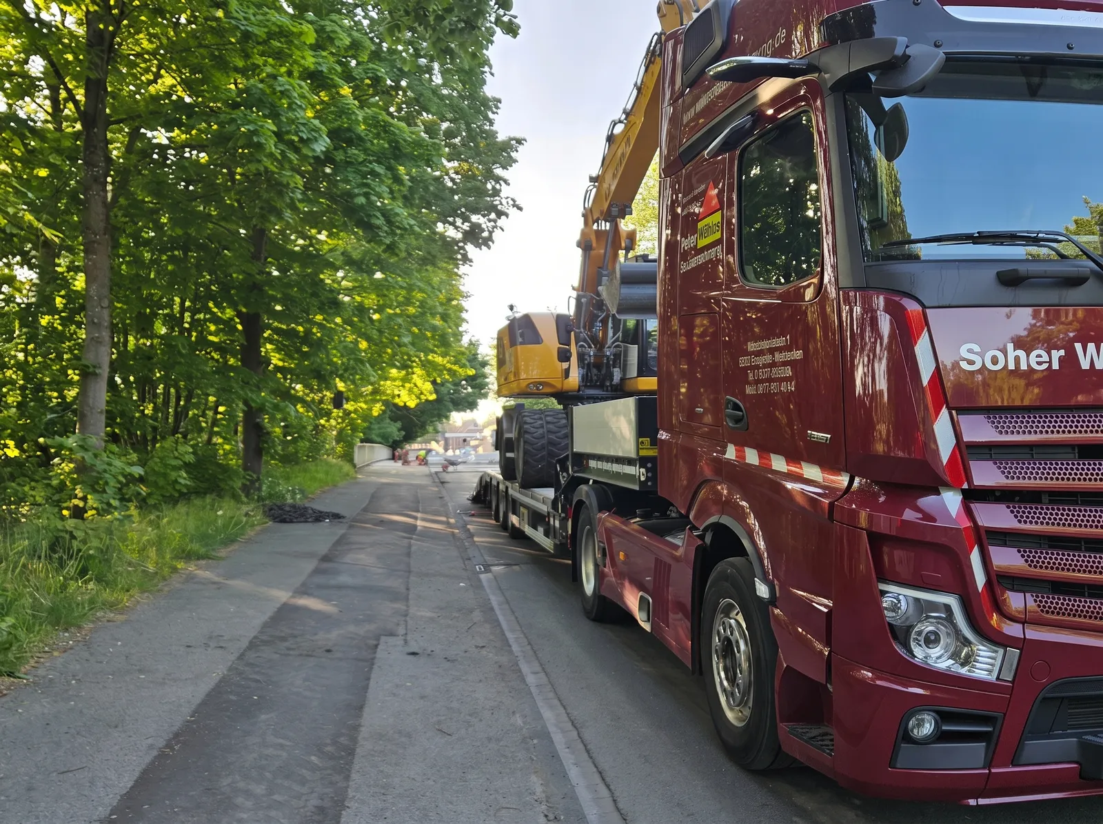 Anlieferung des Baggers per Tieflader mit LKW der Peter Willms Bauunternehmung in Münster-Handorf