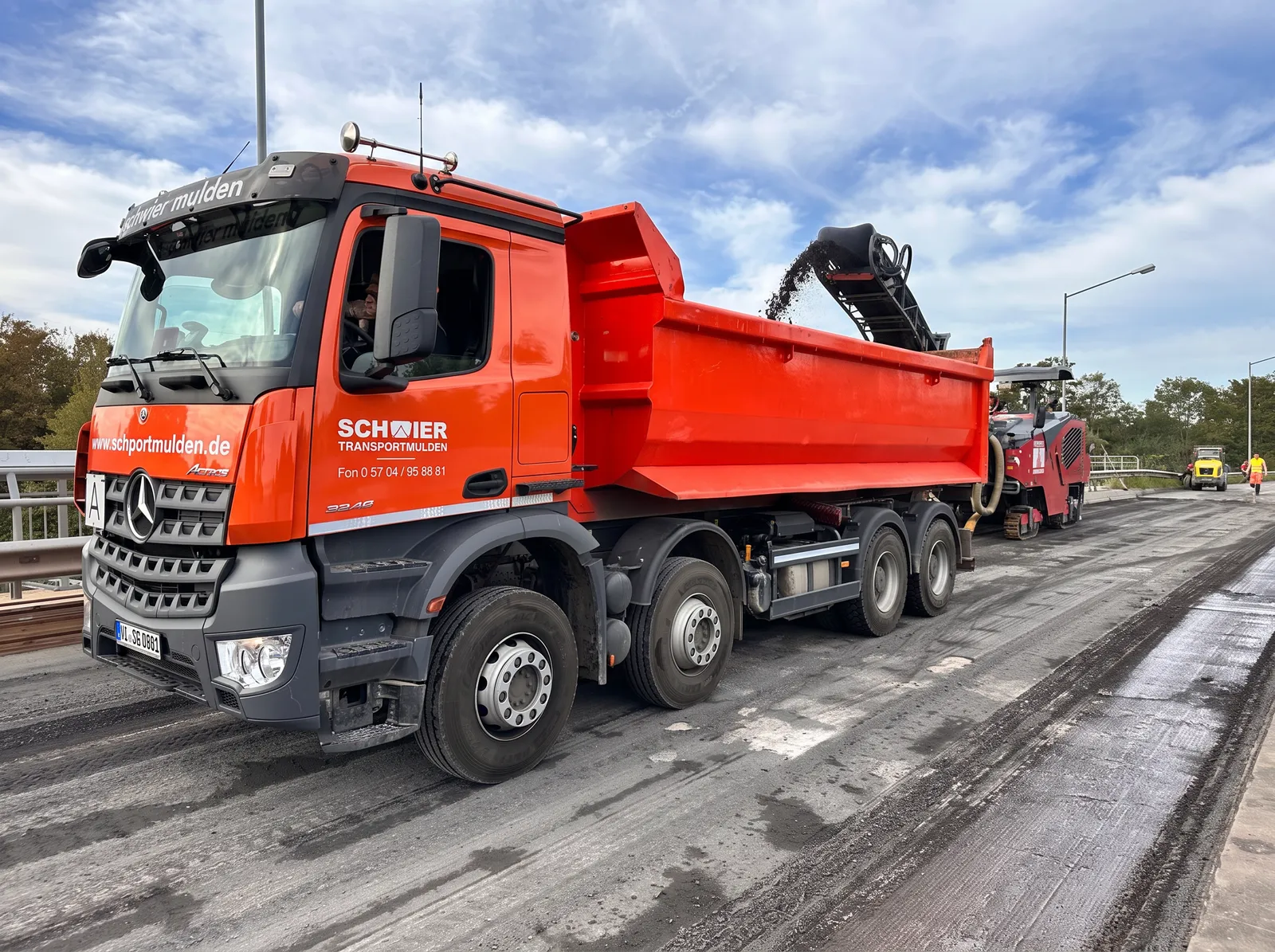 Straßenfräse und Abtransport des gefrästen Asphalts per LKW auf der Brücke