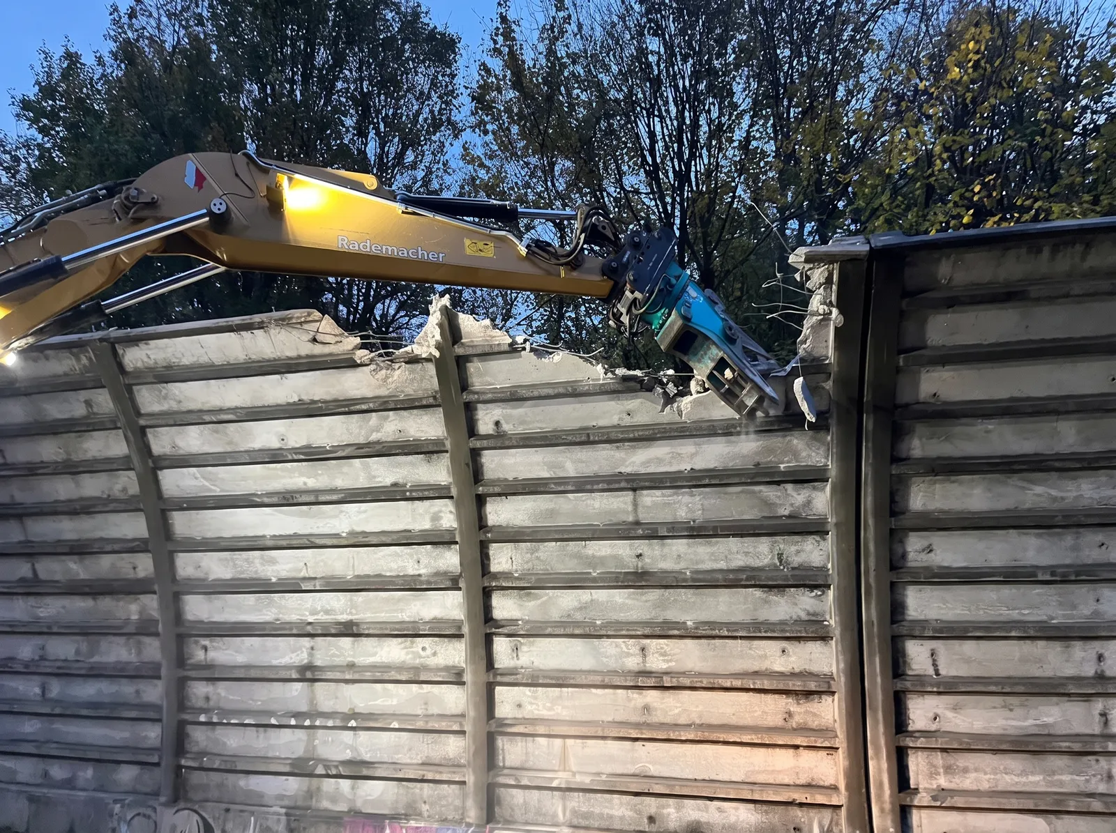 Abbruch der Betonwand mit Betonzange an der Lärmschutzwand