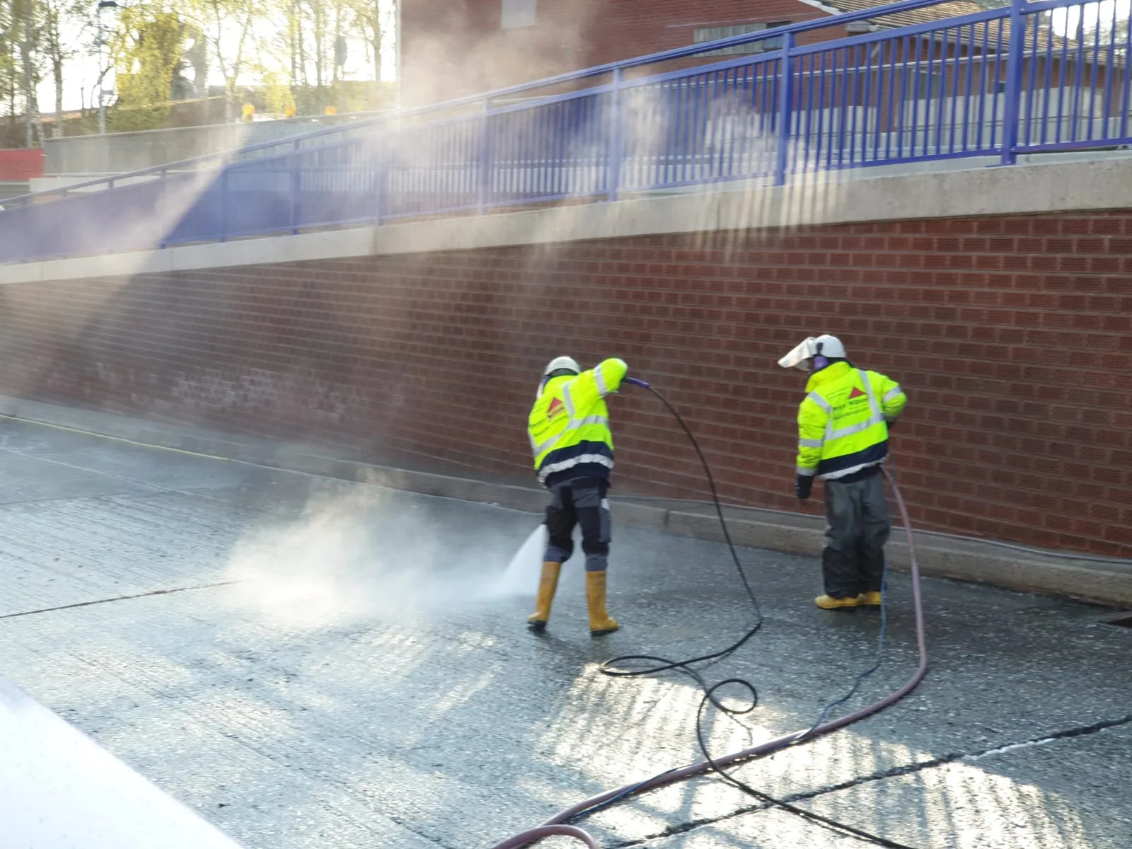 Kolonne beim Höchstdruck-Wasserstrahlen am Trogbauwerk